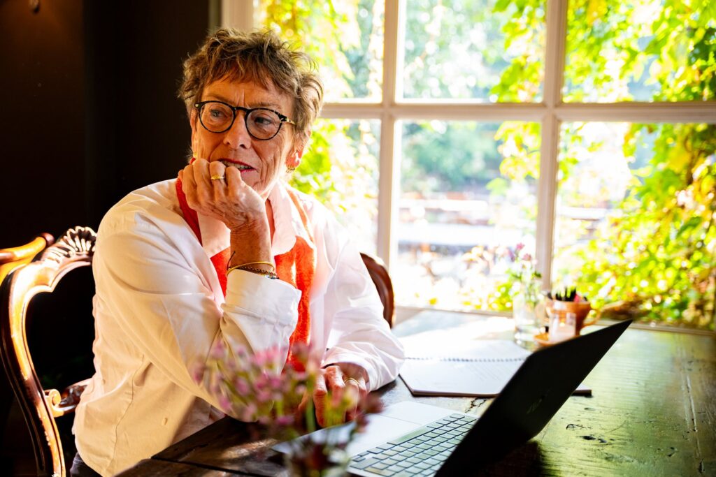 Gwen Dudok van Heel aan tafel met haar laptop, in gesprek